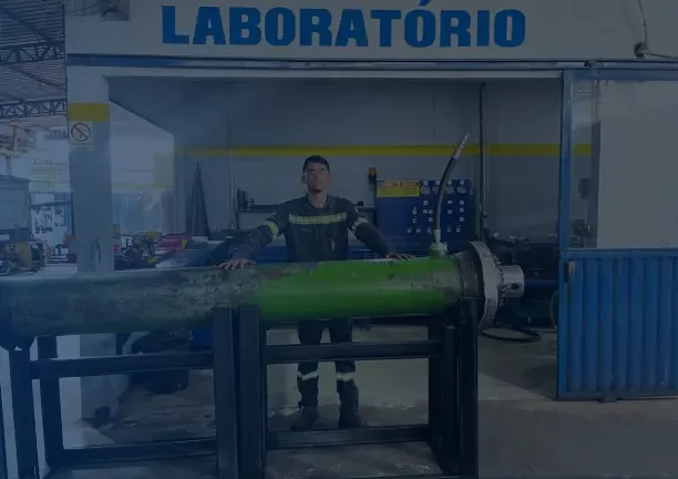 Laboratório hidráulico com cilindro montado em bancada de teste e profissional da equipe